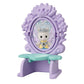 The Calico Critters Fairytale Tower features a petite lavender toy vanity with a green seat and a mirror reflecting an adorable animal figurine dressed in a crown and gown—an enchanting addition to any flower-themed furniture collection.
