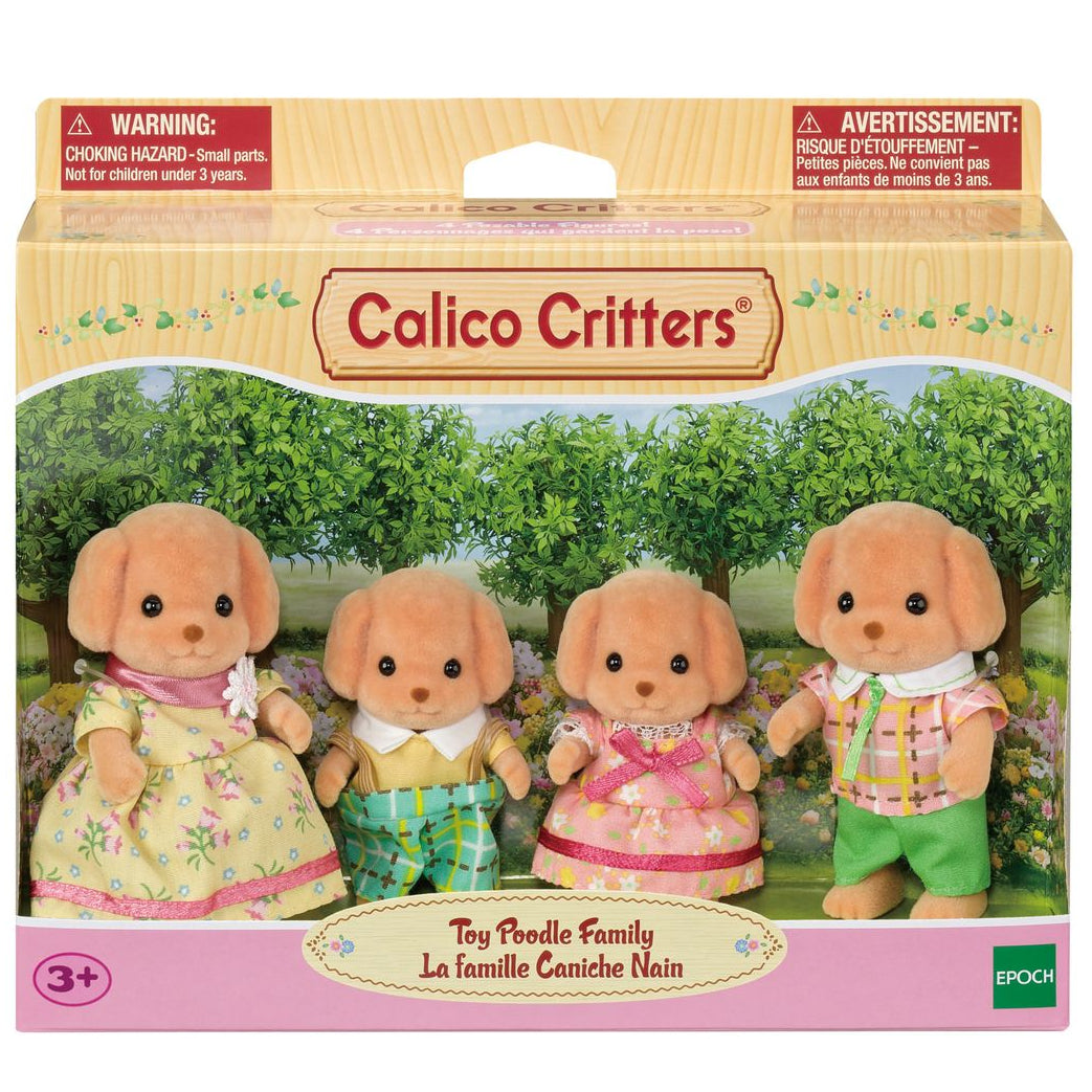 Box of Calico Critters Toy Poodle Family featuring four plush Toy Poodle figures dressed in removable pastel fabric clothing, posed against a garden background.