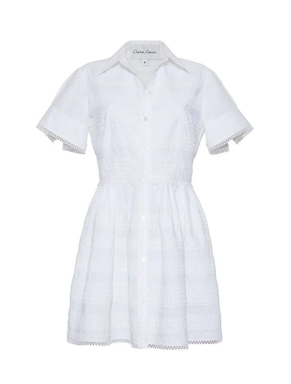 The Kai Mini Dress by Cara Cara is a white short-sleeve, button-down dress with a collared neckline and delicate lace insets on the bodice, skirt, and sleeves for an effortlessly charming style.