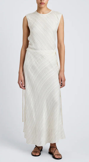 A person wears the Kaia Woven Stripe Skirt by Proenza Schouler White Label, featuring subtle diagonal stripes and an A-line silhouette, paired with black strappy sandals, standing against a plain background.