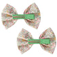 Introducing the Milledeux® Large Bowtie Bow Liberty Katie & Millie B, a set of two exquisite handmade hair clips. These clips feature a charming floral pattern crafted from Liberty of London fabric and are designed with a green center band on grosgrain-covered alligator clips.