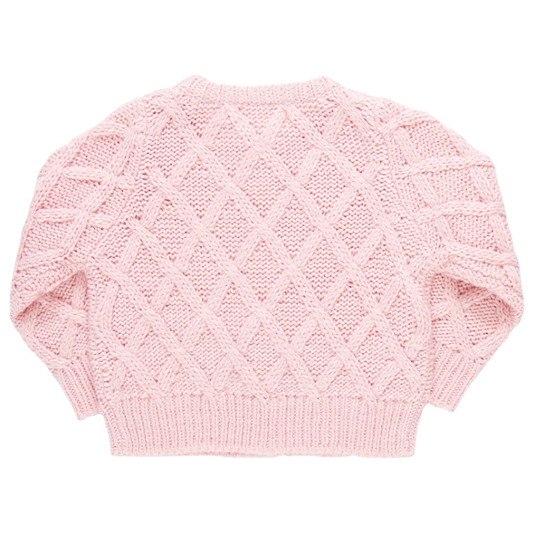 This image shows the Pink Chicken Girls' Katrina Sweater, a long-sleeve knit sweater in pink with a diamond pattern design. The sweater features glitter button closures and has ribbed hems, cuffs, and neckline.