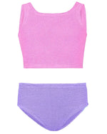 The Hunza G Girl's Duo Lyra Bikini, featuring a textured pink crop top and high-waisted purple bottoms, is laid flat on a white background.