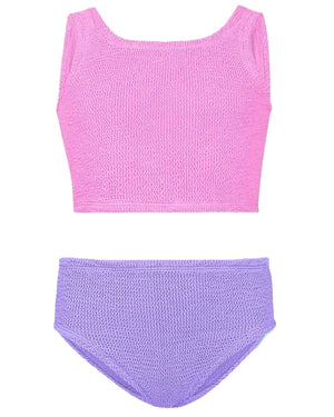 The Hunza G Girl's Duo Lyra Bikini, featuring a textured pink crop top and high-waisted purple bottoms, is laid flat on a white background.