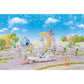Calico Critters’ Floral Fantasy Skyship set features a Latte Cat baby dressed in a whimsical fairy costume, gathering with other toy animal figures in a pastel fantasy landscape adorned with clouds, a crescent moon, skyship carriages, and trees beneath a blue sky sprinkled with twinkling stars.