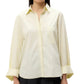 A woman wears the TWP Next Morning Shirt—an oversized light yellow Italian cotton button-down with chest pocket and wide sleeves—paired with dark pants for a relaxed look.