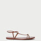The Lara Sandal by Loeffler Randall features timber brown nappa leather, thin straps, a toe loop, and an ankle buckle, shown against a plain white background.