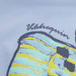 Close-up of Vilebrequin's Boys' Fish Tee: oversized organic cotton, relaxed cut, with a puff-ink print of a striped sphinx head beneath "Vilebrequin.