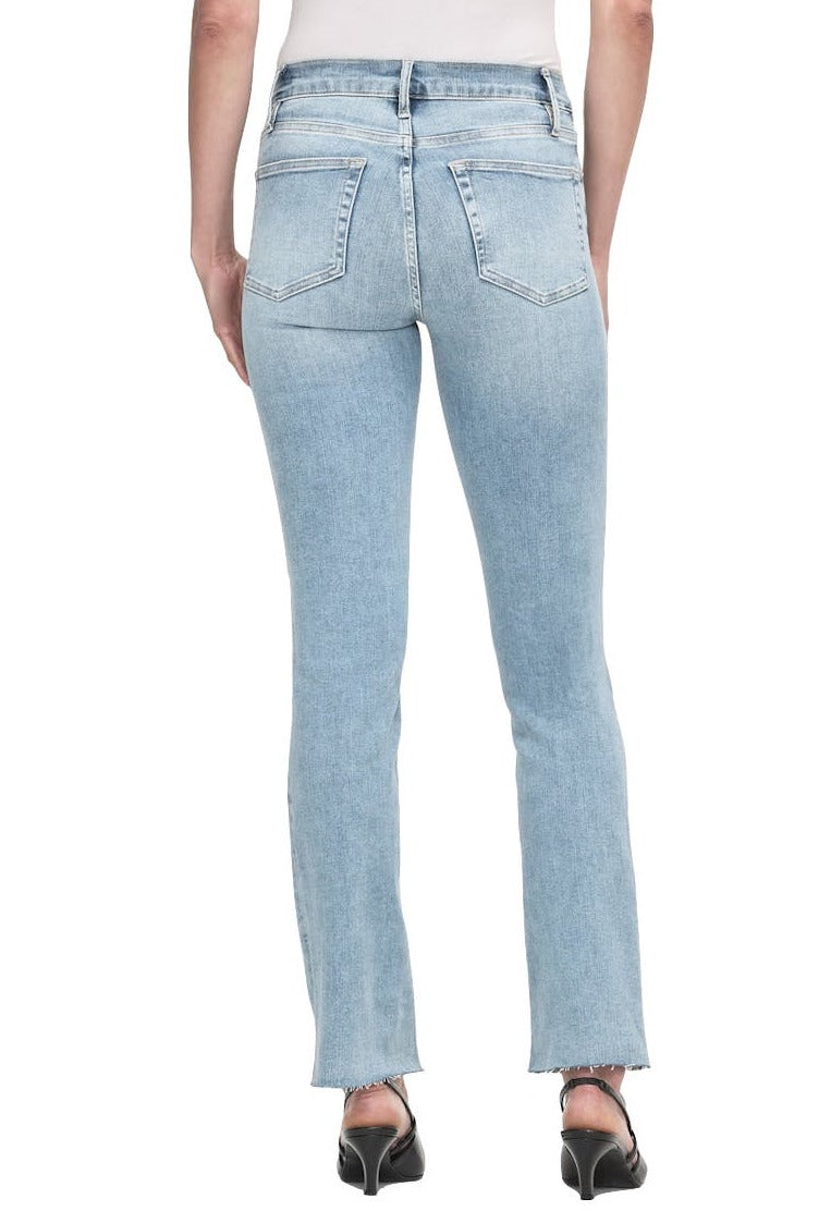 Person wearing light blue Frame Le High Straight Raw After jeans and black heels, shown from the back, with visible back pockets and raw hem at the ankles. The sustainable stretch denim gives a comfortable fit while maintaining a chic look.