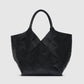 The Lili Braided Leather Tote by Anine Bing, a spacious black leather bag featuring a braided finish and dual handles, is showcased against a plain light gray background.