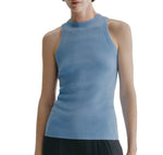 A person wearing the Lisa Yang Amya Tank in light blue—a women’s sleeveless rib knit top with a crew neckline—paired with black pants, shown from shoulders to hips against a white background.