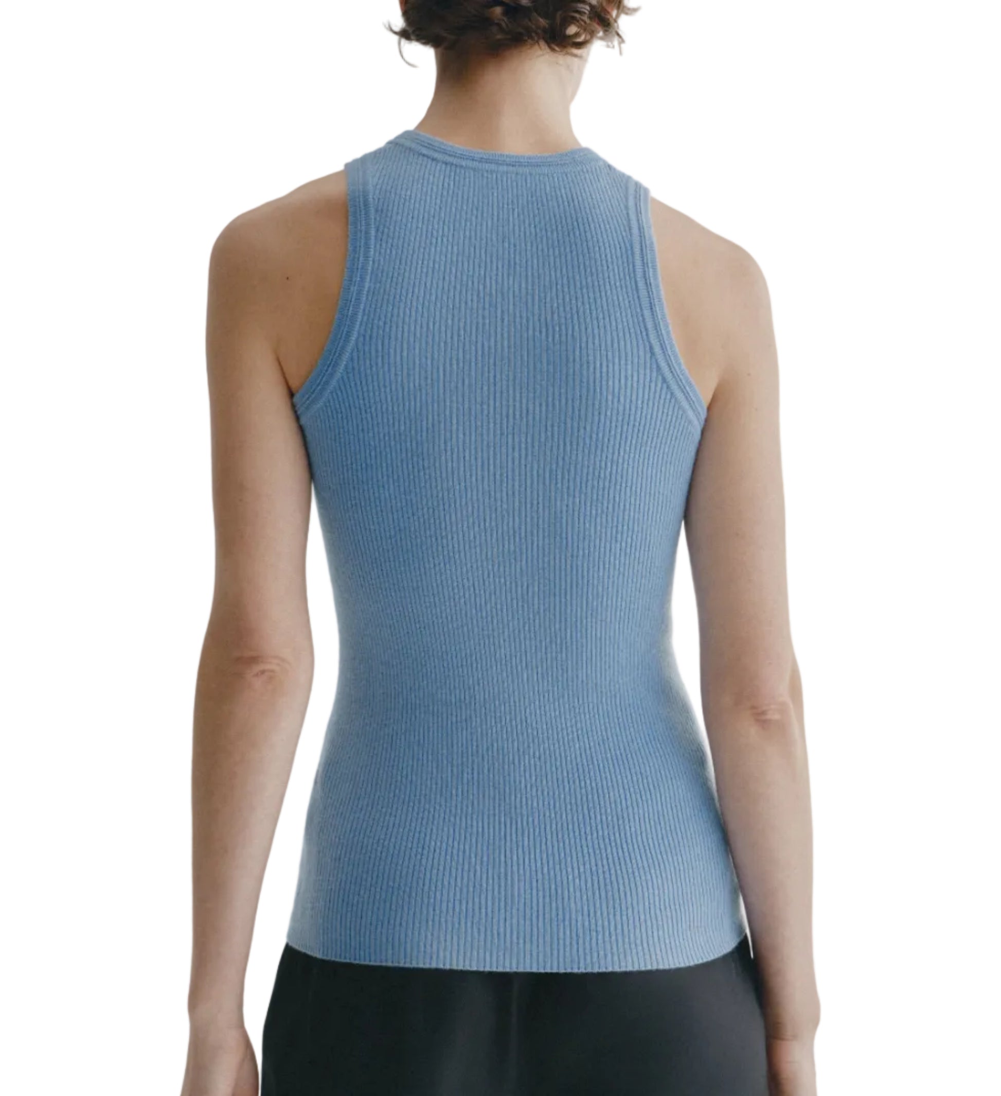 A person is shown from the back against a white background, wearing the Lisa Yang Amya Tank in light blue paired with black pants.