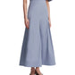 A woman wears the Lela Rose Seam Detail Skirt—a light blue, high-waisted, ankle-length A-line in soft cotton poplin with pleats—paired with a matching blouse and dark heels.