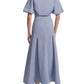 A person wearing Lela Rose's Seam Detail Skirt in light blue with a collared, short-sleeve top—an absolute wardrobe essential—and black low-heeled slingback shoes, shown from the back.