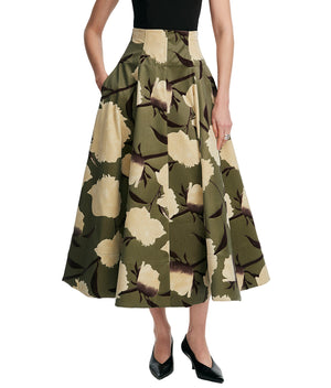 A person wearing the Lela Rose Parker Floral Velvet Skirt with a beige floral pattern, paired with a black sleeveless top and black pointed-toe flats.