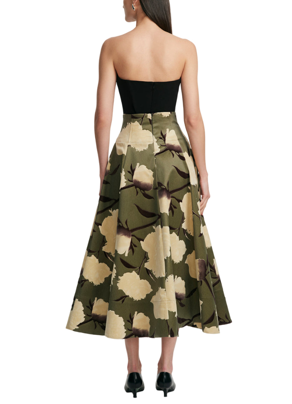 A woman seen from behind wears the Lela Rose Parker Floral Velvet Skirt, a black and olive floral circle skirt with a corseted waist.