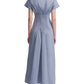 A woman is seen from the back wearing Lela Rose’s Smocked Back Dress, a light blue cotton poplin midi with cape cap sleeves and a ruched, fitted waist.