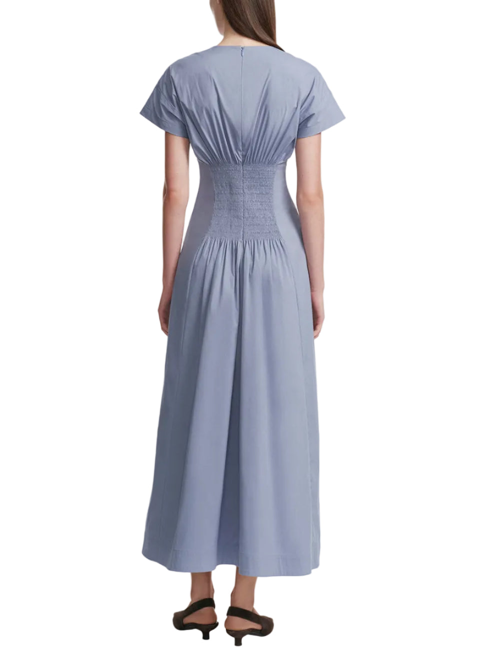 A woman is seen from the back wearing Lela Rose’s Smocked Back Dress, a light blue cotton poplin midi with cape cap sleeves and a ruched, fitted waist.