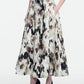 A person wearing a sleeveless black top, the Lela Rose Ikat Polka Parker Skirt with pockets, and black heels stands against a plain white background.