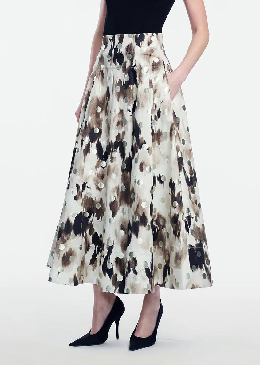 A person wearing a sleeveless black top, the Lela Rose Ikat Polka Parker Skirt with pockets, and black heels stands against a plain white background.