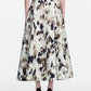 A person wearing a black top and a high-waisted, ankle-length Lela Rose Ikat Polka Parker Skirt, featuring a beige and black abstract pattern, seen from the back, paired with black heels.