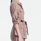 A woman stands in profile against a plain light background, wearing the Lela Rose Melange Crepe Camp Shirt in taupe melange, featuring chest pockets and a belt.