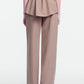 A person stands facing away against a plain white background, wearing the Lela Rose Melange Crepe High Waisted Pant with a tailored leg, paired with a matching beige melange crepe tailored jacket featuring a peplum waist.
