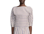 A person wearing the Lela Rose Striped Cotton Dolman Sleeve Top—a boat-neck, navy and red striped piece—paired with a matching vertical-stripe skirt for an effortlessly chic workwear look.