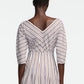 A person is shown from the back wearing the Lela Rose Striped Cotton Dolman Sleeve Top in cream, featuring diagonal and vertical stripes, a V-shaped neckline, and three-quarter dolman sleeves for a stylish yet professional look.