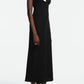 A woman wears the Lela Rose 3D Peony Embroidered Fluid Crepe Twisted Detail Dress—a sleeveless black midi dress with a draped neckline and pink peony embroidery—paired with nude heeled sandals.