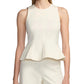 A woman wears the Lela Rose Stretch Cotton Halter Top—a cream, sleeveless, tailored-fit piece with a flared hem—along with matching pants, standing against a plain white background.