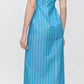 A person shown from the back wears the Callas Milano Lou Dress—a blue and white vertically striped, short-sleeve, midi shirt dress in Italian cotton twill—paired with black sandals.