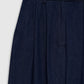 Close-up of the Lou Trouser by Anine Bing in dark blue cotton denim, showcasing a high-rise waistband with belt loops, pleated front detail, and side pockets, photographed against a plain light background.