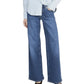 Person wearing a light blue button-up shirt, FRAME Low Rise Le Slim Palazzo women's jeans, and dark pointed-toe shoes, standing against a white background.