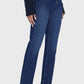 A person wearing Frame’s Le Sleek Straight high-rise, dark blue jeans, a long-sleeve navy top, and black low-heeled shoes stands against a plain light background.