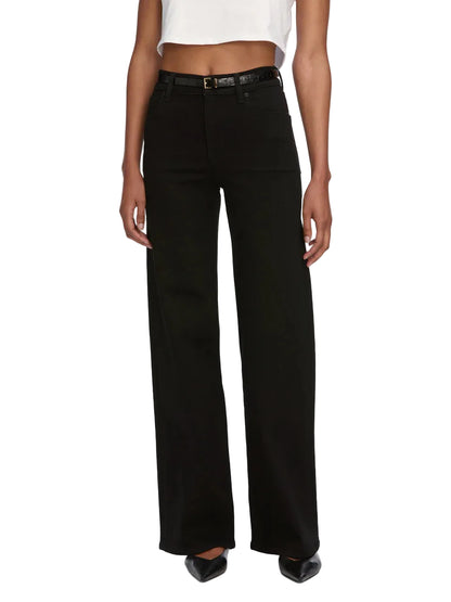 A person wears Frame’s Le Slim Palazzo high-rise, wide-leg black jeans with a black belt, white crop top, and black pointed shoes, standing against a plain background.