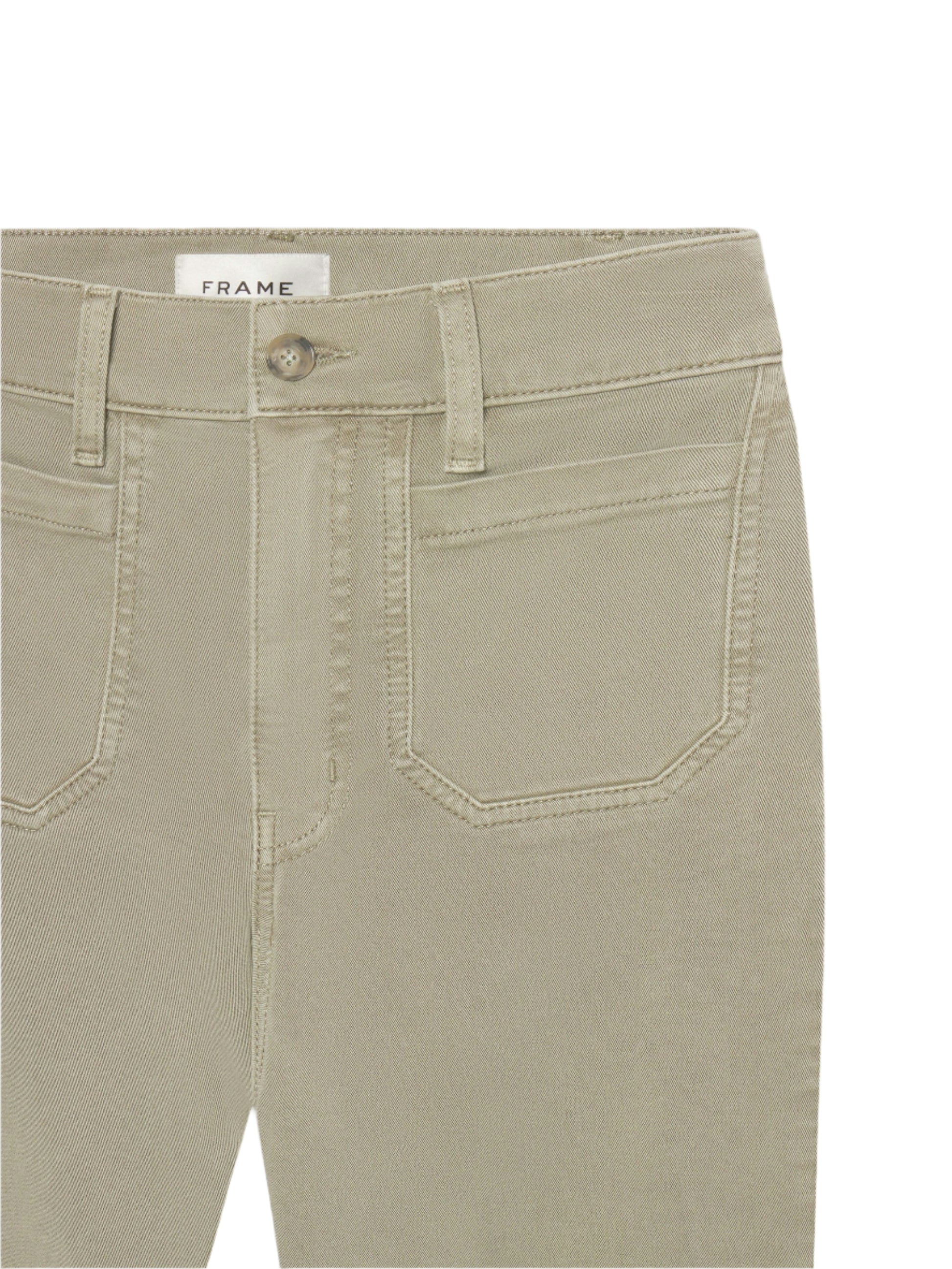 Close-up of the waist and upper thigh of beige Le Slim Palazzo Modernist Pocket jeans by Frame, featuring front pockets, belt loops, button closure, and FRAME label inside. Made from ultra stretch cotton blend for comfort.