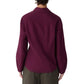 A person is seen from the back wearing the Callas Milano Lucia Top, a long-sleeve, collared dark burgundy cotton poplin shirt paired with olive green pants, set against a plain white background.