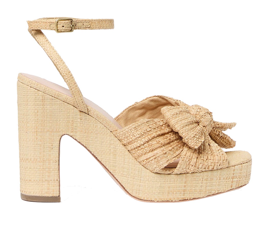 The Loeffler Randall Lucia Platform is a high-heeled sandal featuring a beige pleated design, an ankle strap, natural raffia accents, and a knotted bow on the front.