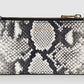 The Lucy Card Holder by Anine Bing is a compact rectangular wallet with a bold black and white python print, gold-toned zipper, and convenient card holder design.