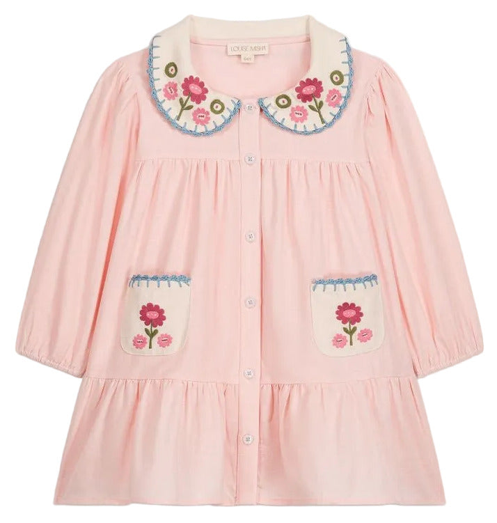 The Louise Misha Baby Girls’ and Girls’ Ysee Dress is a light pink cotton-linen dress featuring long sleeves, a scalloped collar, front buttons, and two pockets. Both the collar and pockets are adorned with colorful floral embroidery for extra charm, while delicate hand-crocheted finishes complete this beautiful floral embroidery dress.