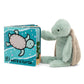 A plush turtle toy rests beside the Jellycat's "If I Were A Turtle Book," showcasing an illustration of this delightful sea creature.