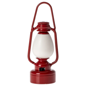 The Maileg Vintage Lantern, Mouse - Red is a charming red and white miniature lantern with a metal handle on top and a glass enclosure.