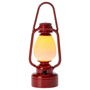 The Maileg Vintage Lantern, Mouse in Red is a metal-crafted lantern with a retro design, offering a soft, glowing light powered by a battery.