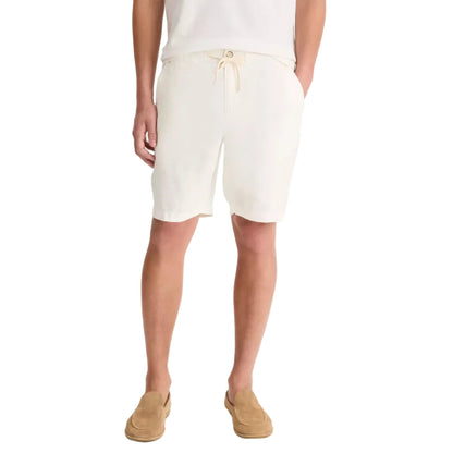 A person wears a white t-shirt, tan loafers, and vince Patch Pocket Drawstring Short—cream, breathable with a drawstring waist—standing hands-in-pockets against a white background.