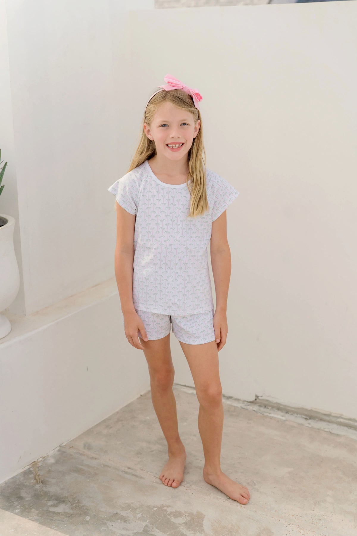 A little girl in a white polka dot pajama set made from Pima cotton from Lila & Hayes Girls' Emery Short Set.