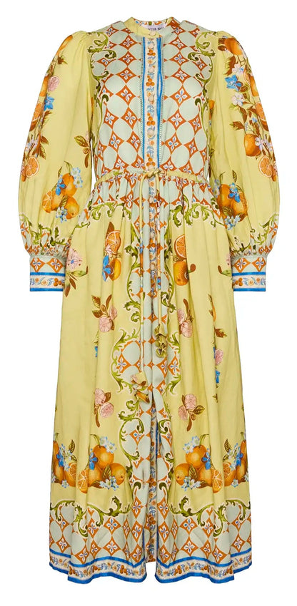 The Hunter Bell NYC Lillian Dress is a long, floral-patterned piece featuring puffed sleeves, a cinched waist, and charming button-front styling with orange and blue designs on a graceful white background.