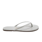 The Lily Glitters Sandal by Tkees features a single silver glittery flip-flop design with thin straps and a flat sole, shown in a side view on a white background.