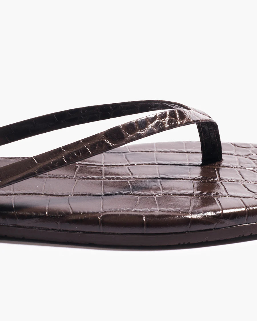 Close-up of the Tkees Lily Square Toe Croc Sandal, featuring dark brown crocodile-embossed leather, a square toe, and simple thong straps.