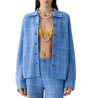 A woman styles the Guest in Residence Dylan Plaid Shirt in blue with a yellow bikini top and layered shell necklaces for a modern Western-inspired look.